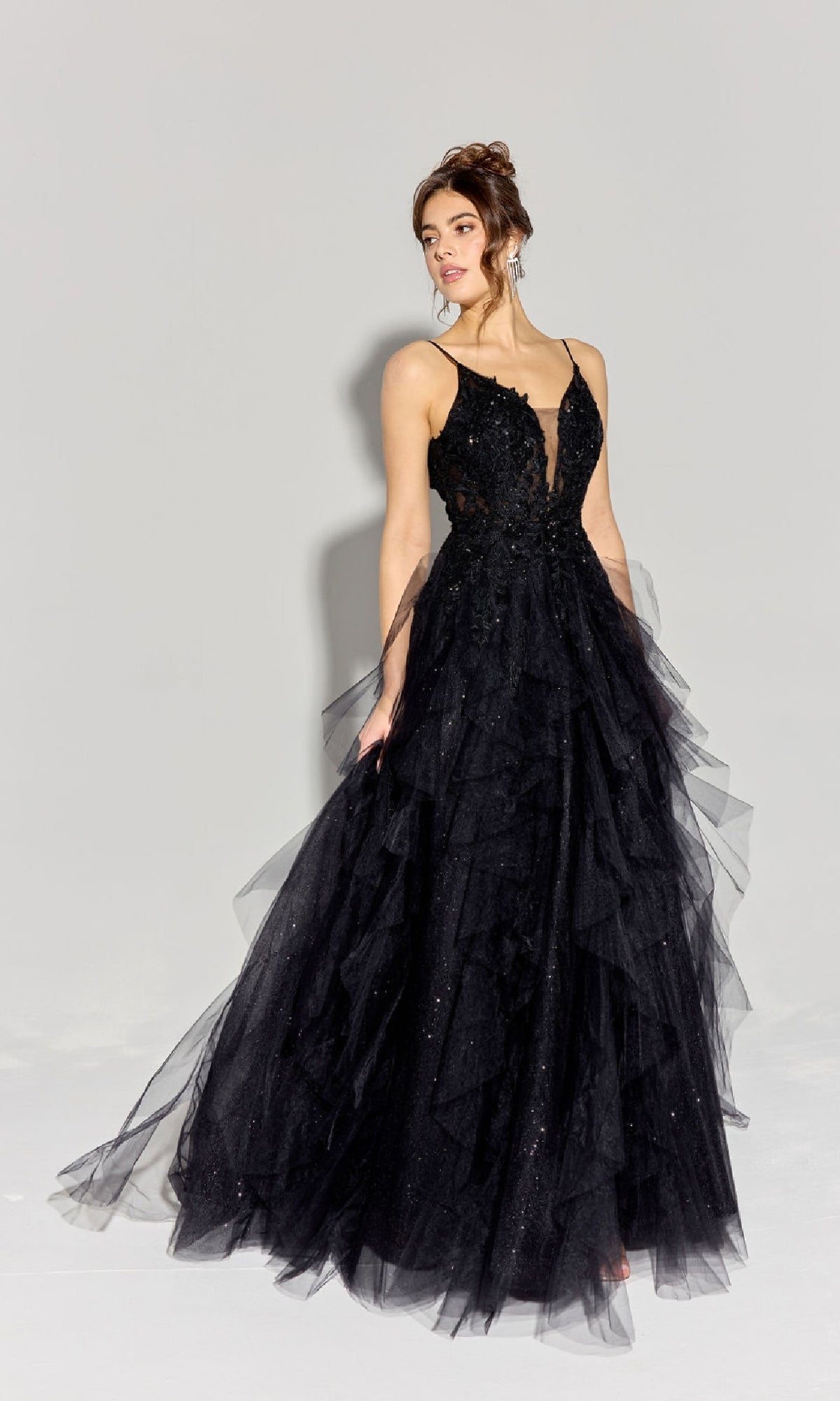 A woman poses against a plain light background wearing the Eureka EK188 Ruffled Long Glitter Prom Ball Gown, featuring a sleeveless design, v-neckline, and full tulle skirt.
